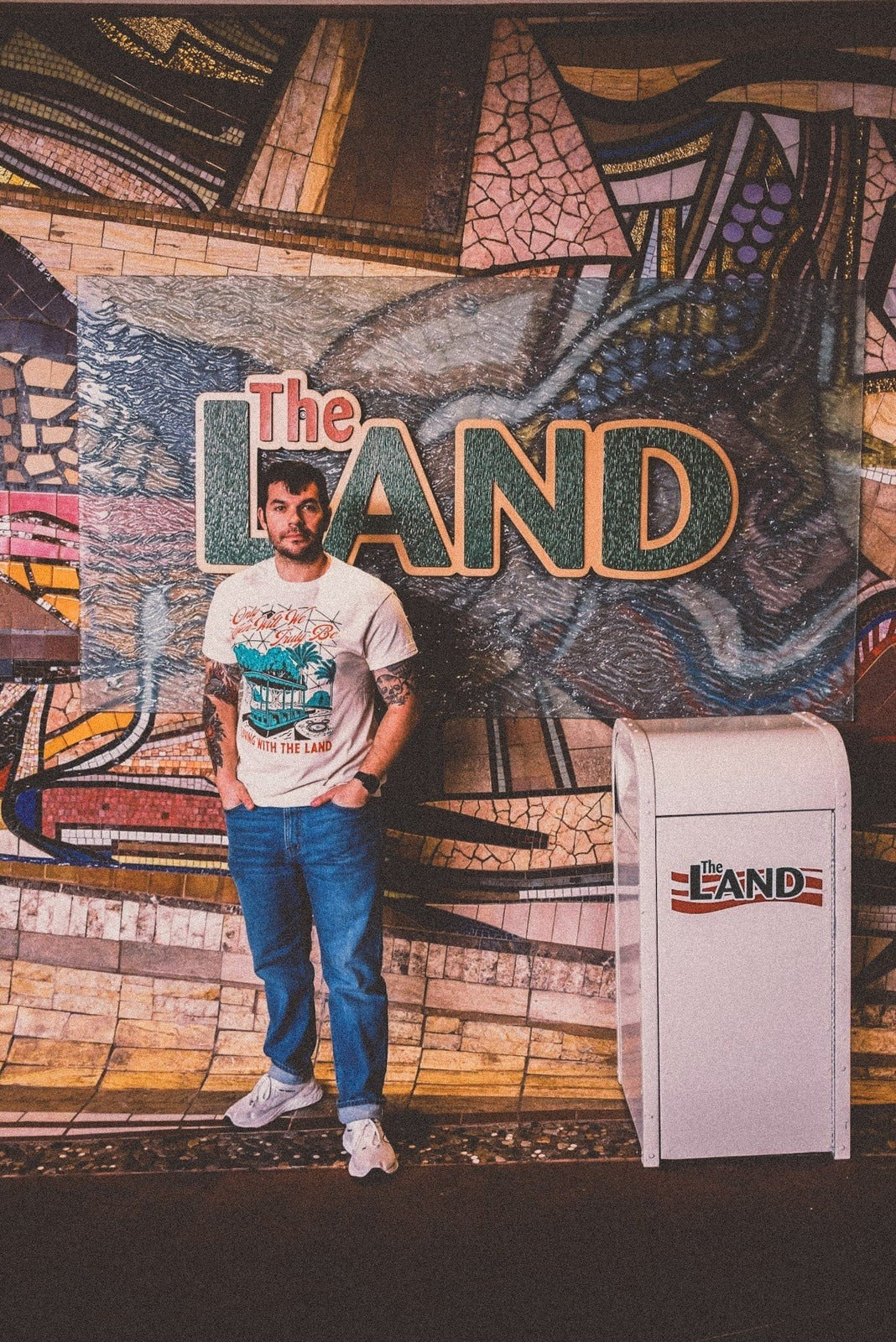man wearing the landscapes of tomorrow Disney-Inspired tee in front of The Land ride at Epcot Disney World